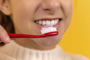 En flicka borstar tänderna.