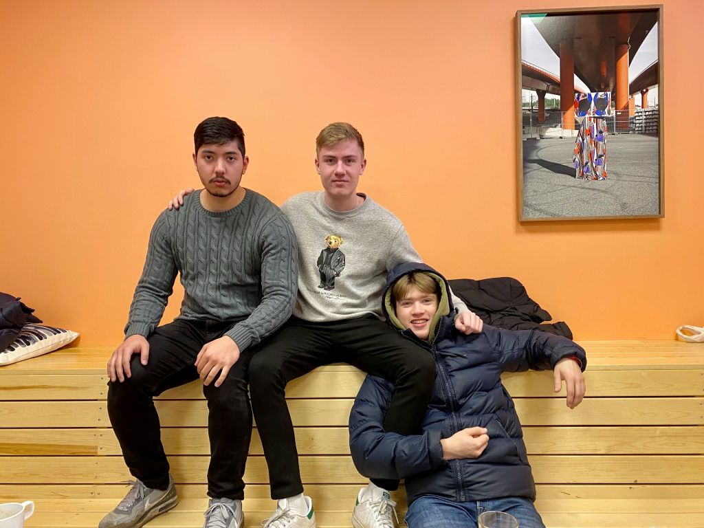 tre ungdomar sitter på en bänk