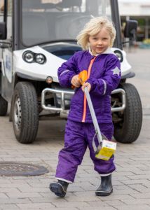 En flick går med en skräpplockare i handen