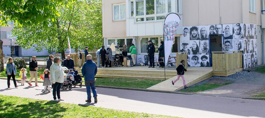 Människor som pratar med varandra framför en husfasad´.