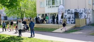 Människor som pratar med varandra framför en husfasad´.