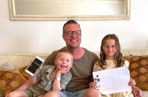 En pappa med varsitt barn på sidan tittar in i kameran och ler.