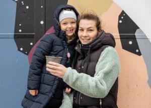 en flicka och hennes mamma ler ini kameran,