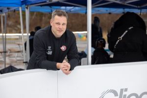 En man står framåtlutad och tittar in i kameran.