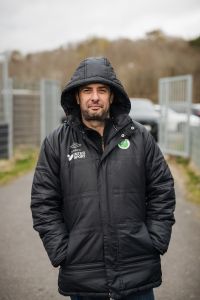 En man i täckjacka ler in i kameran.