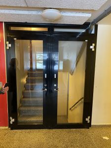 Bilder föreställer en glasdörr som delar av trapphuset.